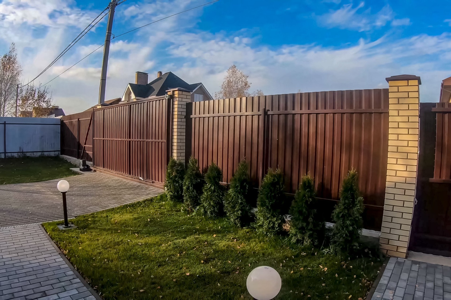 Fence and gate made of brown corrugated metal profile